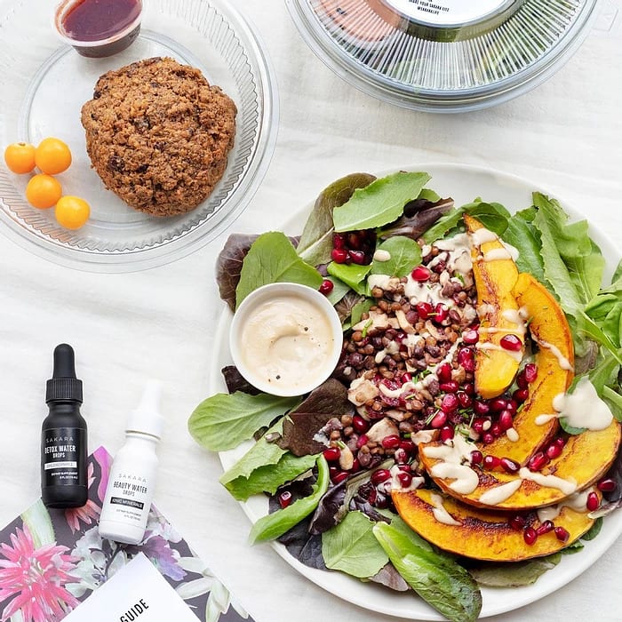 A photo of a salad with some supplements next to it