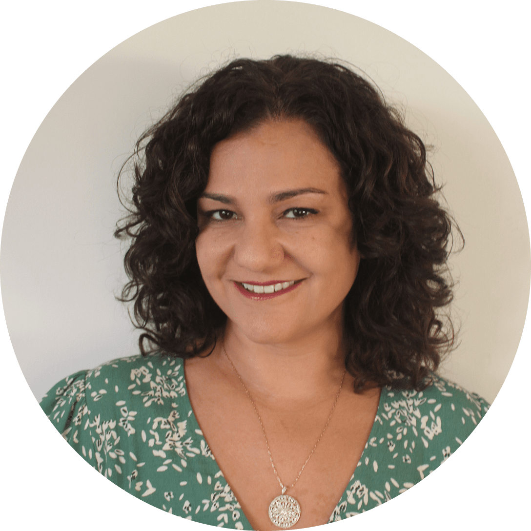 Midlife woman with curly hair and a green blouse