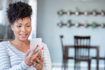 Beautiful mature woman uses smart phone for telemedicine appointment with doctor